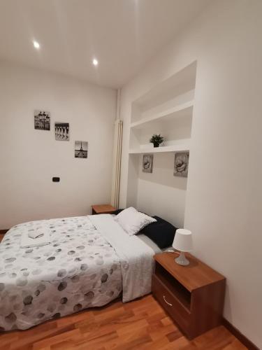 una camera bianca con letto e comodino di Orio Home a Bergamo