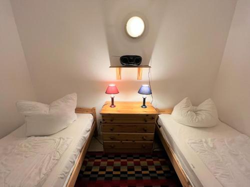 um quarto com 2 camas e uma mesa de cabeceira com 2 candeeiros em Ferienpark Sierksdorf App 561 - Strandlage em Sierksdorf