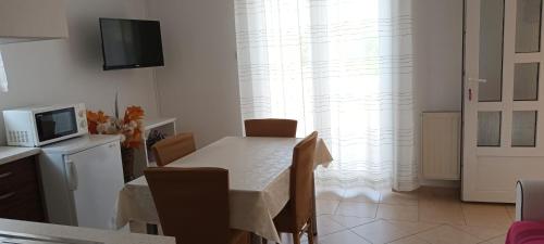 a dining room with a table with chairs and a television at Apartments Nella in Sveti Anton