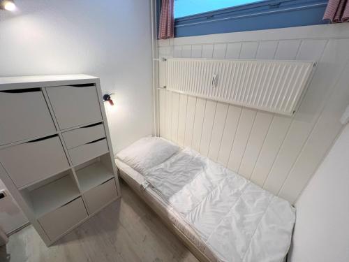een kleine kamer met een bed en een plank bij Ferienpark Sierksdorf App 495 - Strandlage in Sierksdorf