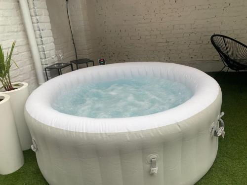 a large white bath tub sitting on the grass at les thermes du beffroi in Calais