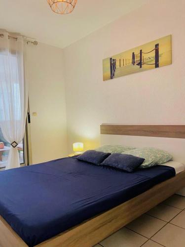 une chambre avec un grand lit avec des draps bleus dans l'établissement Le Juana II, à Antibes