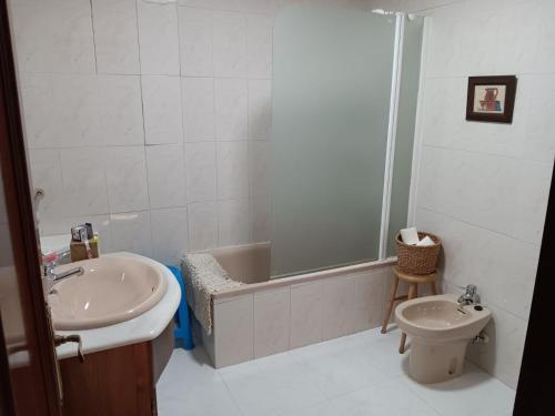 uma casa de banho com um lavatório, uma banheira e um WC. em Duplex Las Piraguas em Arriondas