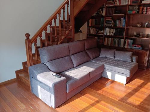 uma sala de estar com um sofá e uma escada em Duplex Las Piraguas em Arriondas