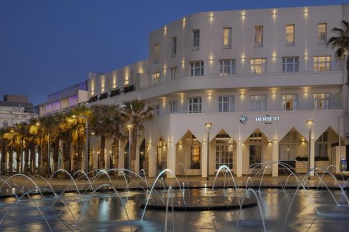 a hotel with fountains in front of a building at The Herbert Tel Aviv in Tel Aviv