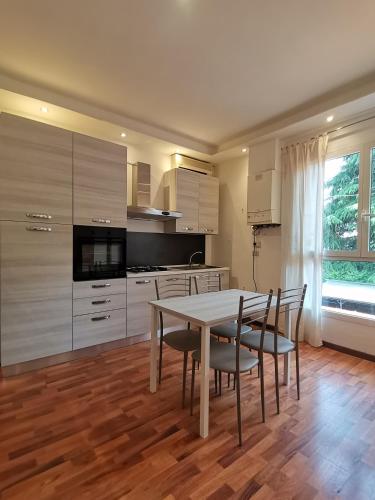 una cucina con tavolo e sedie e una cucina con armadi di Orio Home a Bergamo