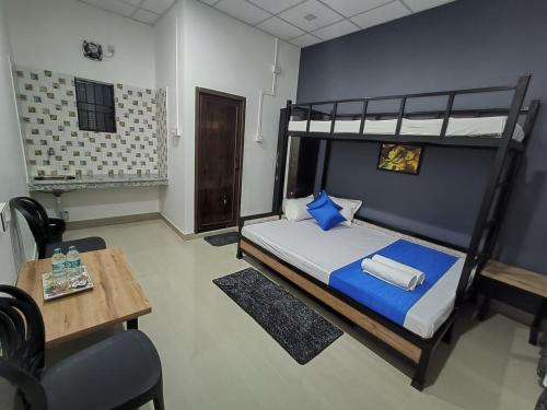 a bedroom with a bunk bed and a table at The Corner Inn (Lodge) in Guwahati