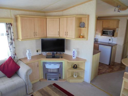 a small living room with a desk with a television at 8 Berth panel heated on Coral Beach (Willerby Westmorland) in Ingoldmells