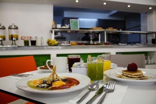 a table with two plates of breakfast food and drinks at Hotel Star Express Puebla - Central CAPU in Puebla