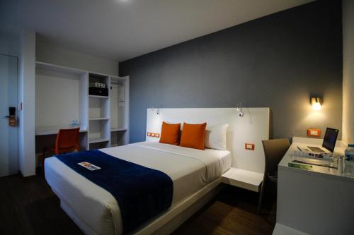 a bedroom with a large bed with orange pillows at Hotel Star Express Puebla - Central CAPU in Puebla