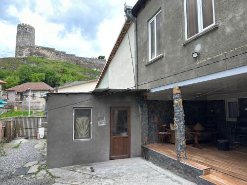 a house with a deck with a castle in the background at Ideal in Akhaltsikhe