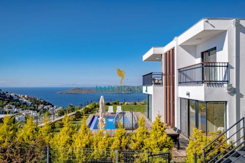 un edificio blanco con piscina y océano en Farilya Villas by Important Group Travel en Bodrum
