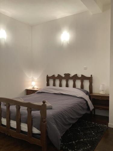 a bedroom with a wooden bed with two night stands at Apartment Centre Historic in Marvejols