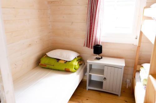 een kleine kamer met een bed en een tafel bij domki szenodo na Jodłowej in Debina