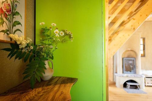 un mur vert avec un vase de fleurs sur une table dans l'établissement Ferienhaus "Am Wegesrand", 