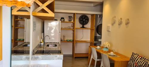 eine Küche und ein Esszimmer mit einem Tisch und einem Waschbecken in der Unterkunft Casa Gostoso Mar in São Miguel do Gostoso