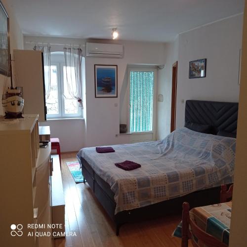 a bedroom with a bed and two windows at Studio Cres in Cres
