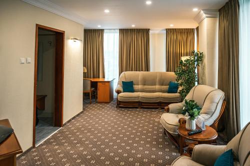 a hotel room with a couch and a chair at Hotel Trotuş in Onești
