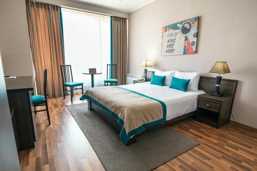 a hotel room with a bed and a table and chairs at Hotel Trotuş in Onești