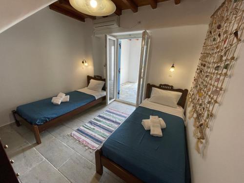 two beds in a room with a mirror at Cycladic style Maisonette with staggering sea view in Agios Sostis Mykonos