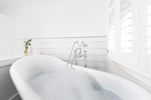 een wit bad in een witte badkamer bij Mordros, St Ives in St Ives