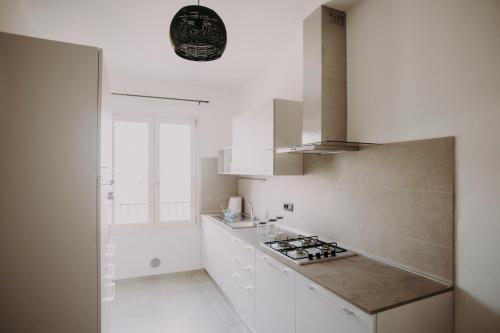 Una cocina con gabinetes blancos y un horno de estufa. en B&B Le Colline, en Campiglio