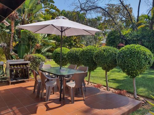Micasa Sucasa Guesthouse في Lephalale: طاولة وكراسي مع مظلة على الفناء