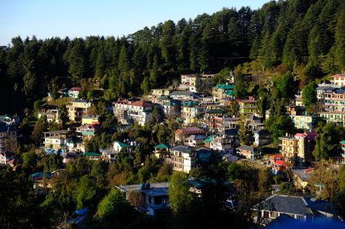 a town on a hill with houses and trees at Mitra Mcleodganj in McLeod Ganj