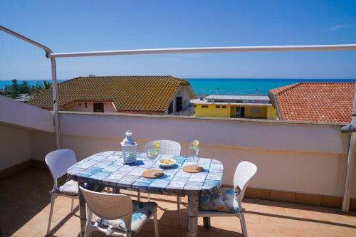 einen Tisch auf einem Balkon mit Meerblick in der Unterkunft Terrazza Marina in Torre di Montalto