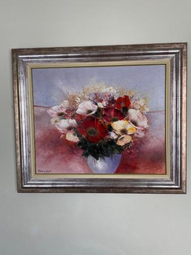 a painting of a vase of flowers on a wall at Oscar Hôtel Le Havre Centre in Le Havre