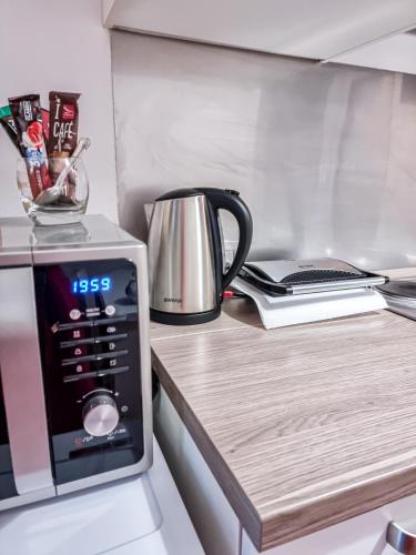 a kitchen counter with a microwave and a tea kettle at Apartment Gallery Zagreb in Zagreb