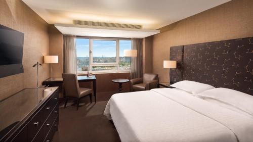 una camera d'albergo con letto, scrivania e finestra di Sheraton Lisboa Hotel & Spa a Lisbona