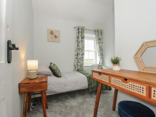 a small bedroom with a bed and a window at Carvannel Cottages in Camborne