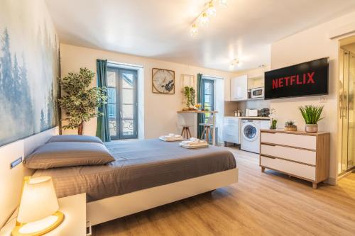 a bedroom with a large bed and a kitchen at Le CosyGreen - Central/Netflix/Wifi Fibre - Séjour Lozère in Mende