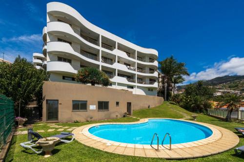 a building with a swimming pool in front of a building at Calheta Victory View by An Island Apart in Calheta