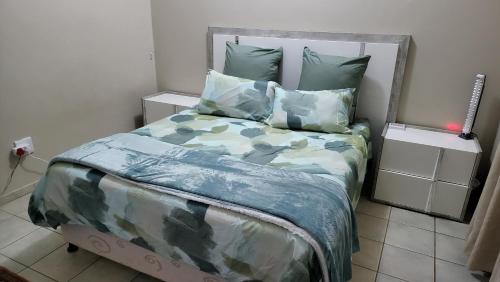 a bedroom with a bed with camouflage sheets and pillows at Little Germany in Waterfall