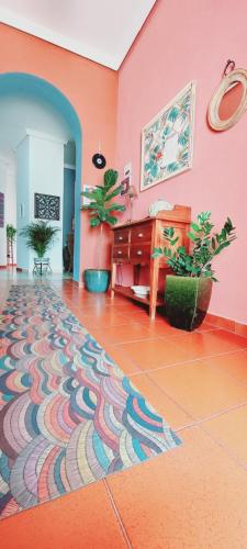 een kamer met een roze muur en een kleurrijke vloer bij Rompeolas Playa in Chipiona