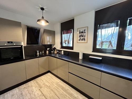 a kitchen with black and white counters and windows at Maggia in Style in Tegna