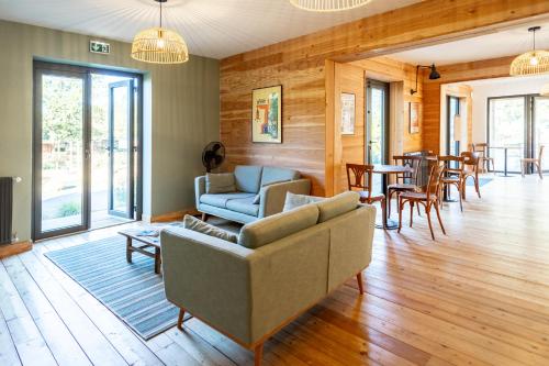 a living room with a couch and chairs and a table at Huttopia Lac de l'Uby - Gers in Cazaubon