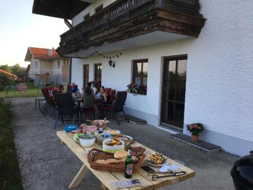 un tavolo in legno con cibo sopra accanto a un edificio di Ferienwohnung Fernblick Breitenberg a Breitenberg