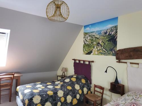 um quarto com uma cama, uma mesa e cadeiras em Chambre d'hôtes Le Cascadou em Banassac