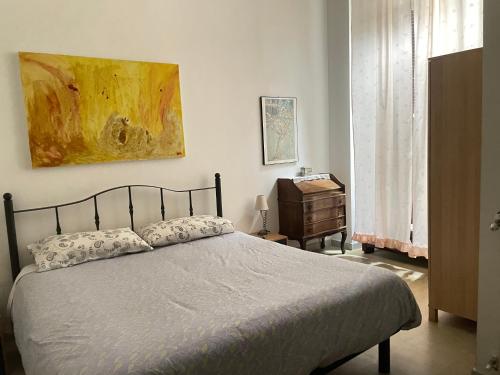 una camera da letto con un letto e un dipinto sul muro di Roman Central House a Roma