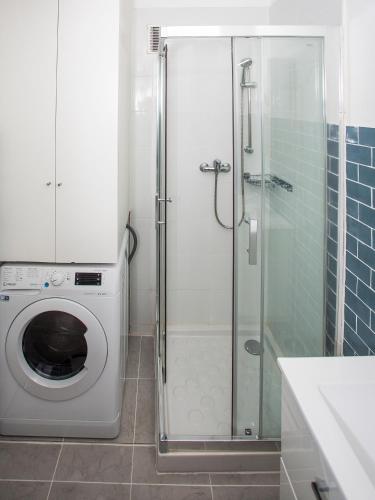 La salle de bains est pourvue d'un lave-linge et d'une douche en verre. dans l'établissement Romantic sea view studio, steps away from the beach, à Antibes