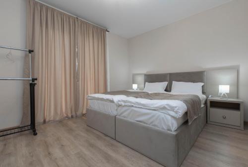 a white bedroom with a large bed and a window at "Panorama" Kakhri in Mestia