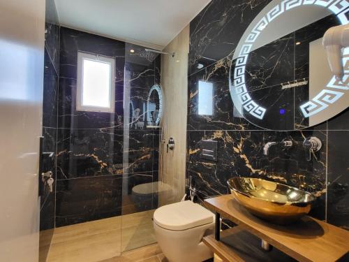 a bathroom with a bowl sink and a toilet at Vila Bello in Ksamil