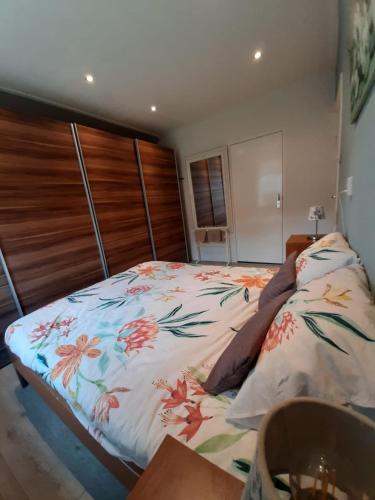 een slaapkamer met een bed met een bloemdekbed bij Klein Eikelenkamp in Wilp