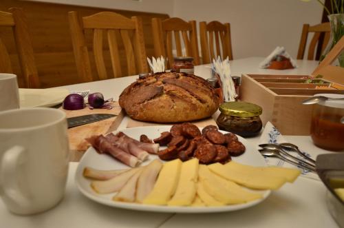 a plate of food on a table with a loaf of bread at Visnyó Vendégház in Nagyvisnyó