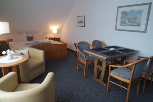 Habitación de hotel con cama, mesa y sillas en Aparthotel Schafshorn, en Schaprode