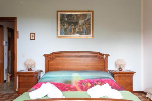 a bedroom with a bed and two dressers and a picture on the wall at La collina dei nonni - Tarzo in Tarzo