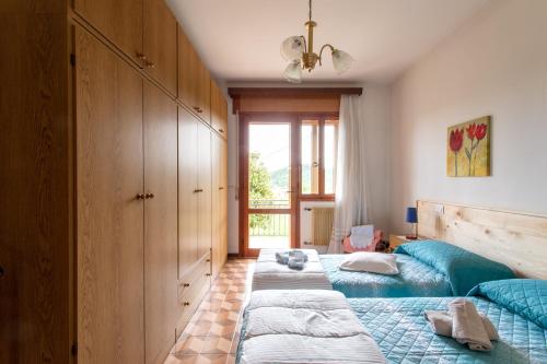 a bedroom with two beds and a window at La collina dei nonni - Tarzo in Tarzo